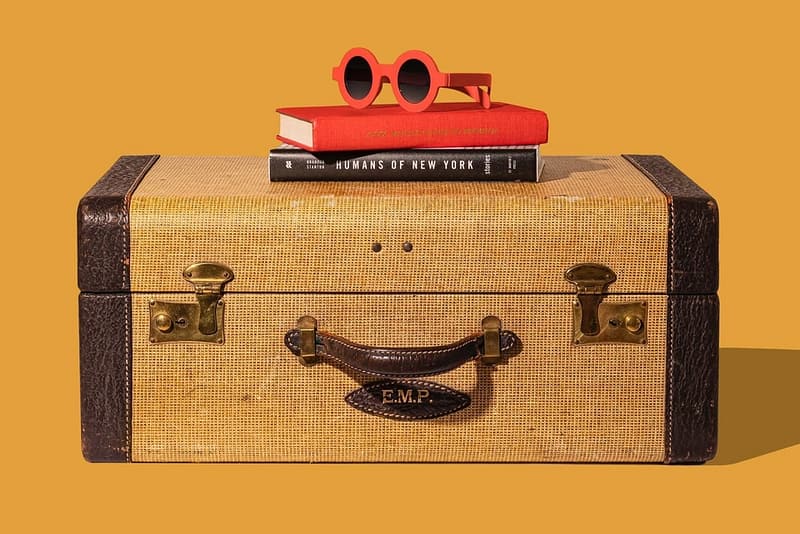 A holiday suitcase with books and sunglasses placed over it